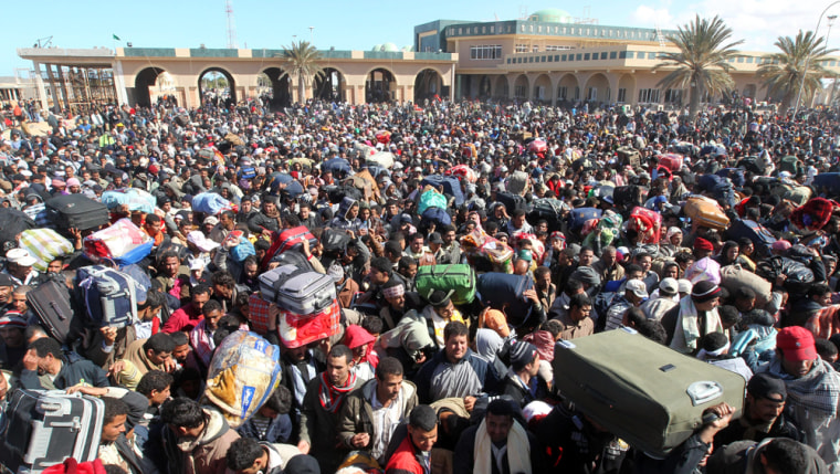 Image: Egyptian residents fleeing the unrest in Libya at the border crossing of Ras Jdir, Tunisia
