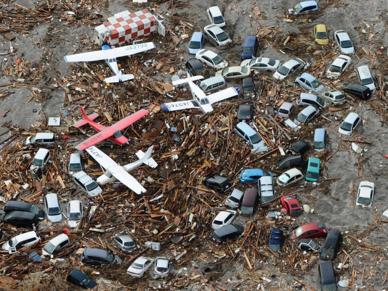 Image: Cars and airplanes swept by a tsunami are pictured among debris at Sendai Airport, northeastern Japan