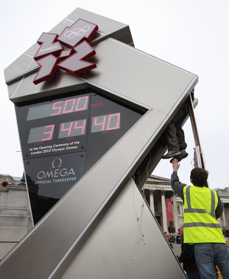Image: A technician climbs into the Olympic countdown clock in Trafalgar Square in central London