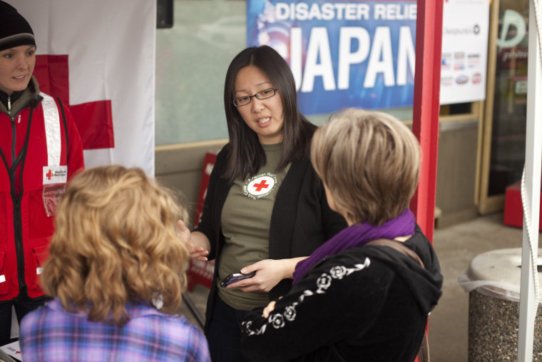 Karen Kim talks to Patti Meyers, right, and her daughter Elisabeth, 12, about earthquake preparedness at the KOMO sponsored Red Cross disaster relief for Japan booth sponsored at Uwajimaya grocery store in Redmond, Washington