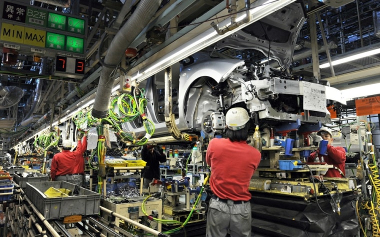 Image: Nissan Motor's workers install engines a