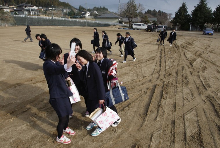 Image: Graduates from Okirai Junior High School in the schoolyard after their graduation ceremony, in Okirai district, Ofunato March 23,