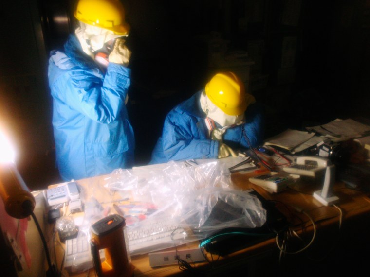 Image: Handout photo from the Japan's Nuclear and Industrial Safety Agency shows Tokyo Electric Power Co. workers recording the status of instruments in a control room at the Fukushima Daiichi Nuclear Power Plant in northeastern Japan