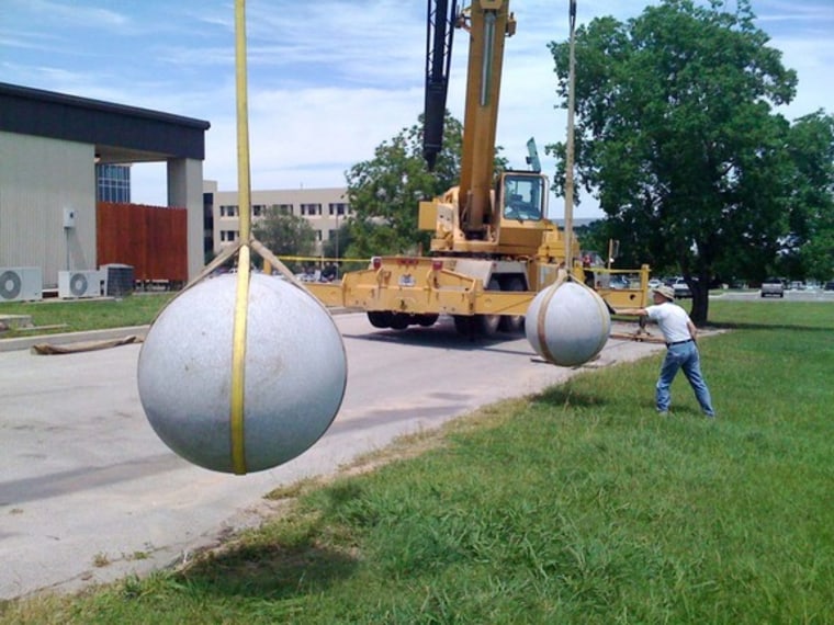 Two 40-foot cranes suspend two granite balls —which average 2,700 pounds each — as they prepare for impact. The experiment at the Southwest Research Institute in Boulder, Colo., was meant to mimic asteroid collisions.