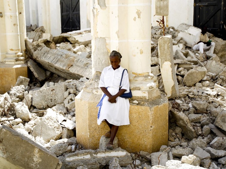 Image: A woman stands inside the destroyed cathedral in Port-au-Prince after attending a mass