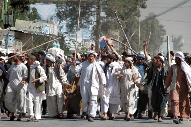 Image: Afghan protestors walk with sticks, as they carry a wounded colleague during a demonstration to condemn the burning of a copy of the Muslim holy book by a U.S. Florida pastor, in Kandahar southern of Afghanistan