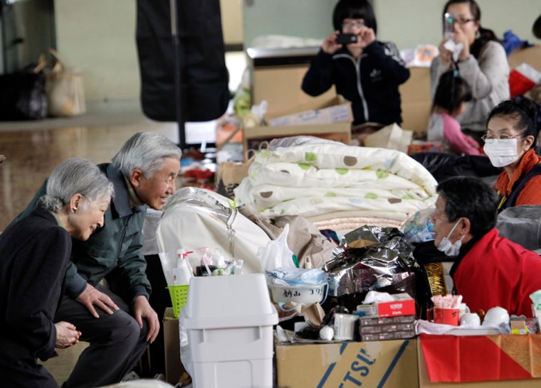 Image: Japan's Emperor Akihito, second from left, and Empress Michiko, left, talk with an evacuee at an evacuation center in Kazo, Saitama Prefecture, Japan