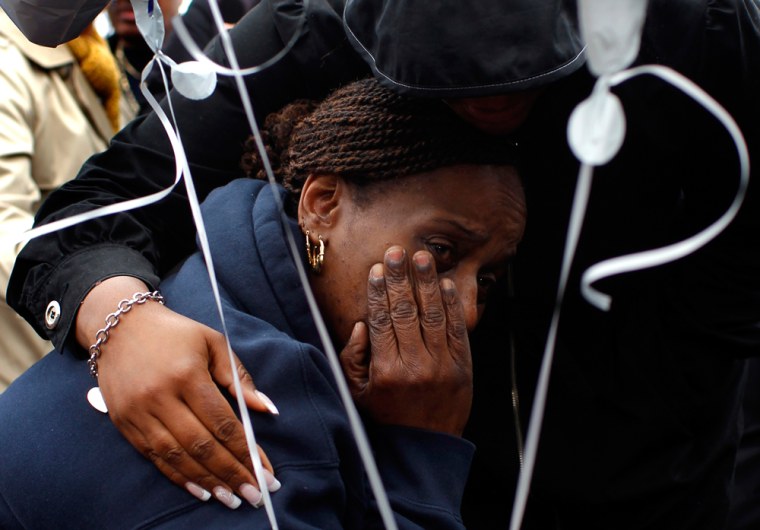 Image: Angela Gilliam, aunt of Lashandra Armstrong, is comforted by a relative near a boat launch at the Hudson River