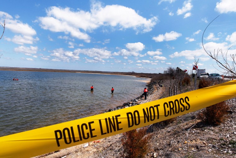 Image: Members of the Suffolk County Dive Team search the Hemlock Cove area for remains of bodies near the Cedar Beach area of New York