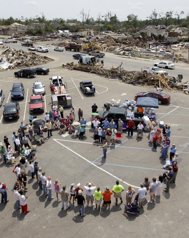 Image: Alberta Baptist Church members form a circle in the parking lot of their destroyed church