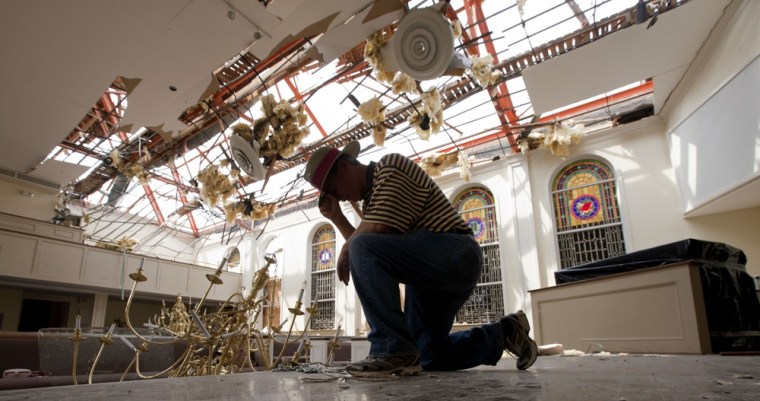 Image: Dan Turner takes a moment to pray in the demolished sanctuary