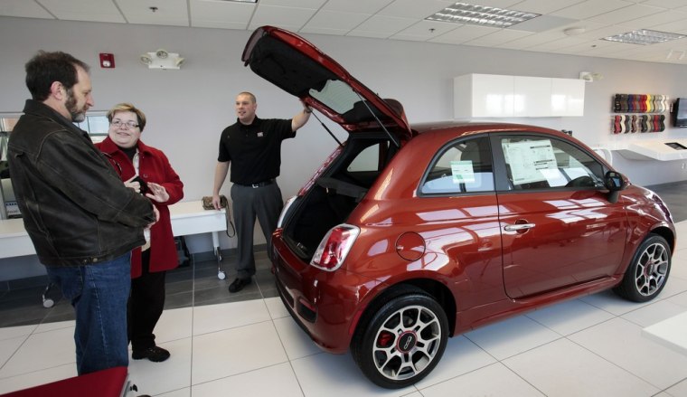Image: A design specialist shows potential customers a 2012 Fiat 500 vehicle at the Golling Fiat dealership in Bloomfield Hills