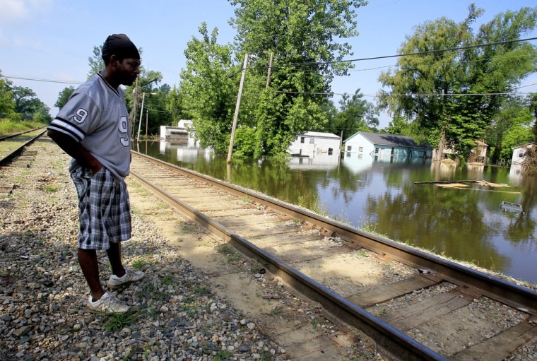 Image: James Carter views his home from near by railroad tracks as flood waters from the swollen Mississippi River inundate his neighborhood in Vicksburg, Mississippi