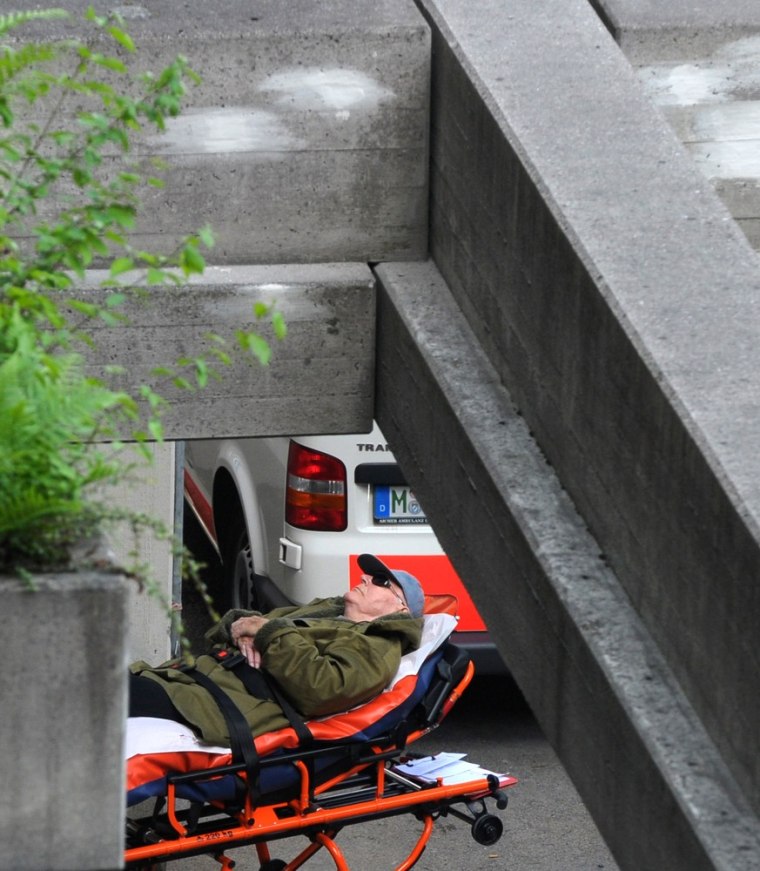 Image: Defendant John Demjanjuk arrives at the courthouse compound on a stretcher for another session of his trial on May 11.