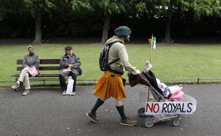 Image: A baby stroller adorned with signs of protest against the upcoming visit of Britain's Queen Elizabeth is pushed through St Stephen's Green in Dublin