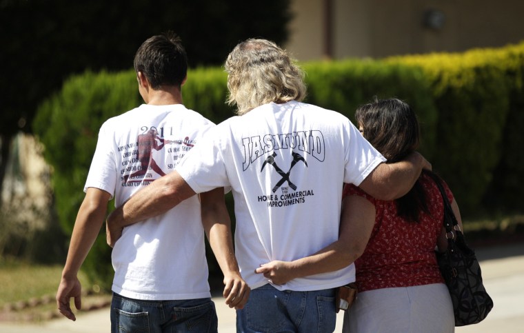 Image: A classmate of one the victims walks with his parents