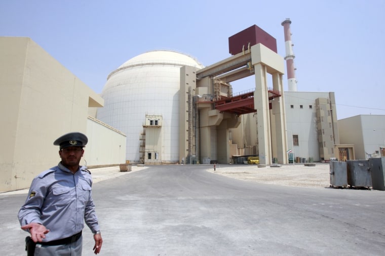 Image: A security official talks to journalists in front of Bushehr main nuclear reactor