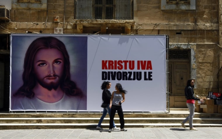 Image: Young women walk past a billboard reading \"Christ Yes, Divorce No\" in Sliema