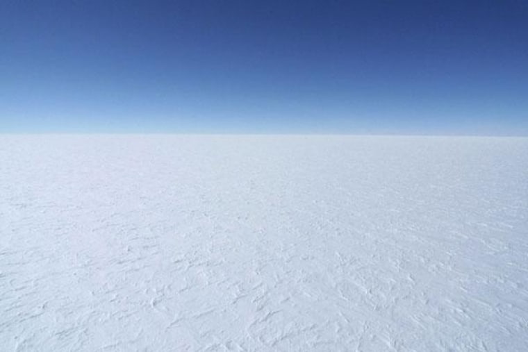 A view of the blue sky and bright white East Antarctic Ice Sheet from a DC-3 airplane.