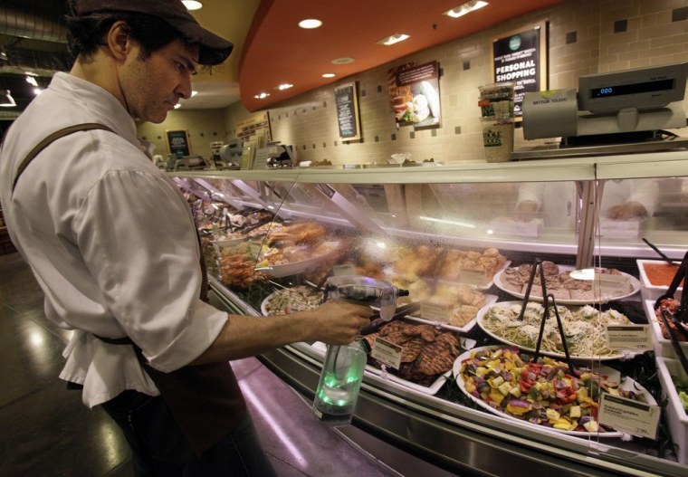 Image: Robert Fente cleans a glass case at the Whole Foods Market in New York with an ionized sprayer.
