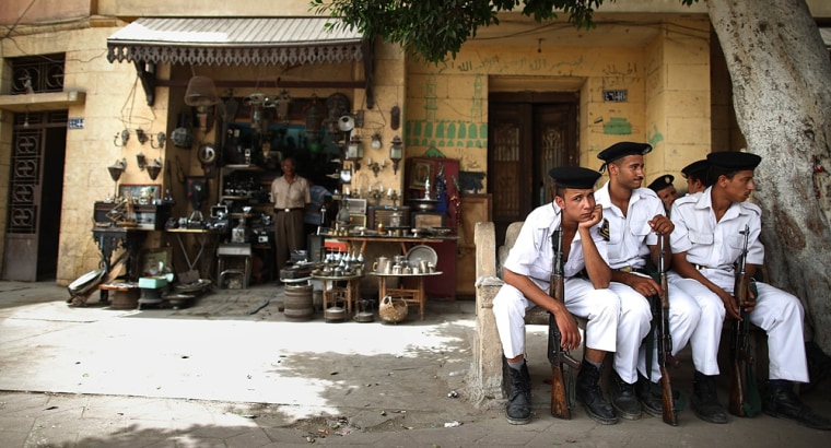 Image: Tourist Police sit in the shade on a road leading to the Coptic Cairo area