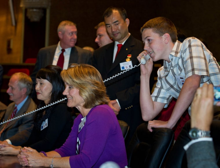 Kenny Fossum, right, youngest son of Expedition 28 NASA Flight Engineer Mike Fossum, is seen at Russian Mission Control in Korolev, Russia speaking to his father shortly after his arrival at the International Space Station on Friday, June 10.