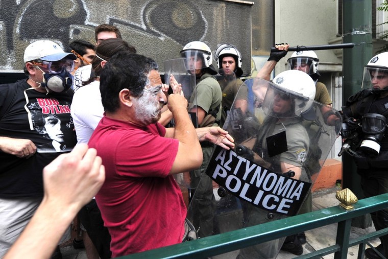 Image: Protestors clash with riot police during a 48-hour general strike in Athens on June 29