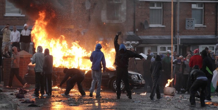 Image: Nationalist youths are seen near a burning car during a protest in the Ardoyne area of North Belfast