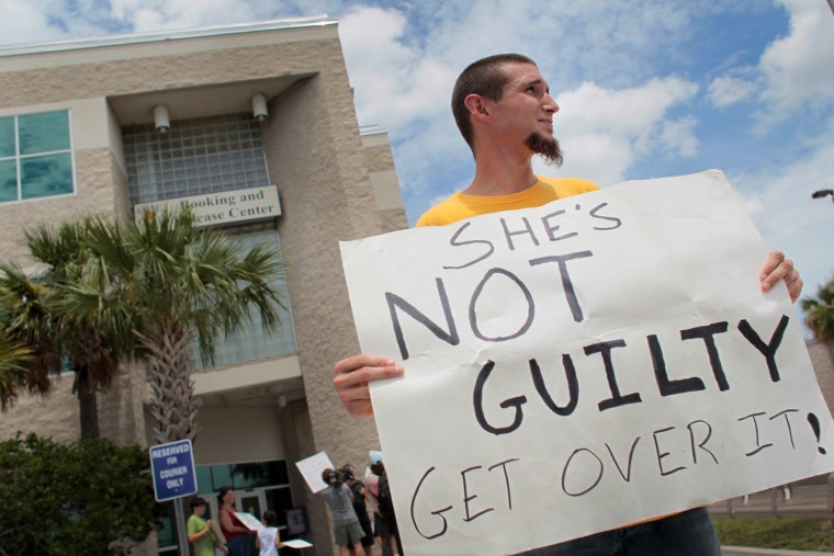 Image: David Antolic from Orlando, Florida stands with a sign in front of the Booking and Release Center