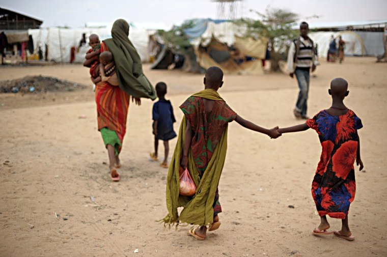 Image: Farhiya (centre) holds her 7-year-old sister Suladan by the hand as they follow their mother and brothers at the reception center of the Dolo Ado refugee camp near the Ethiopia-Somalia border