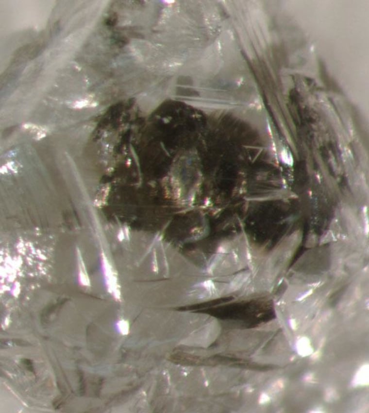Optical photomicrograph of a sulfide-inclusion-bearing rough diamond from the Orapa kimberlite, Botswana.