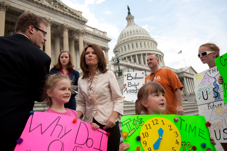 Image: Rep. Miche­le Bachm­ann (R-Mi­nn.) greets a family of protesters.