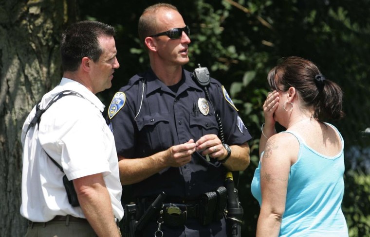 Image: Members of the Akron Police Department talk to an unidentified woman who claimed to be a relative