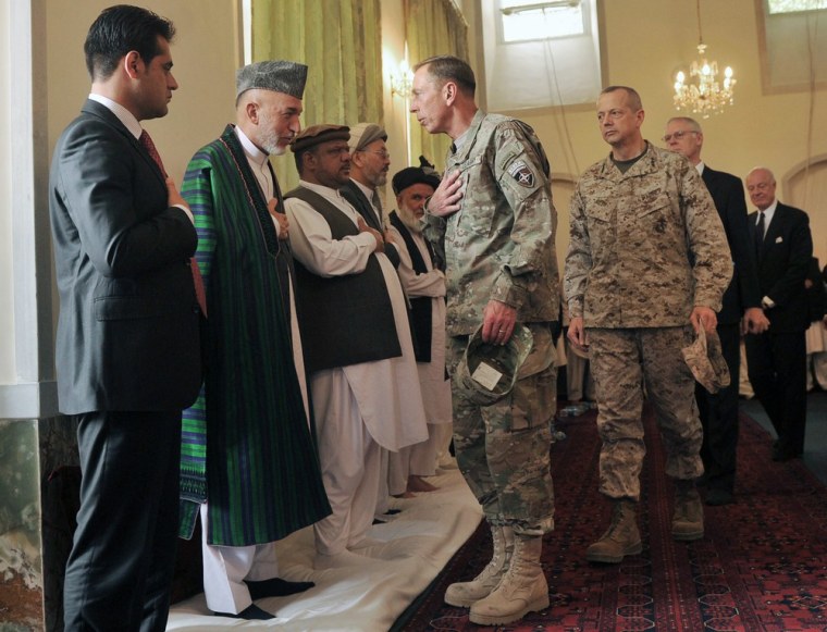 Image: Afghanistan's President Hamid Karzai greets General Petraeus during the funeral ceremony for his younger brother Karzai at the presidential palace in Kabul