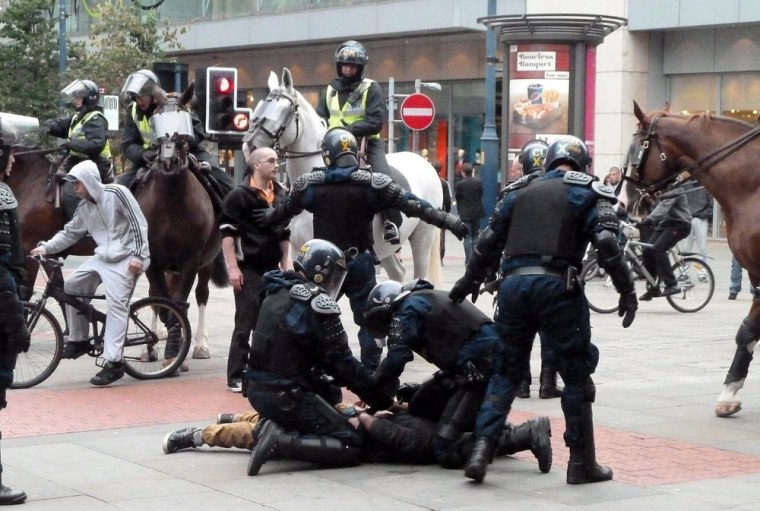 Image: Police restrain a man in Manchester, England