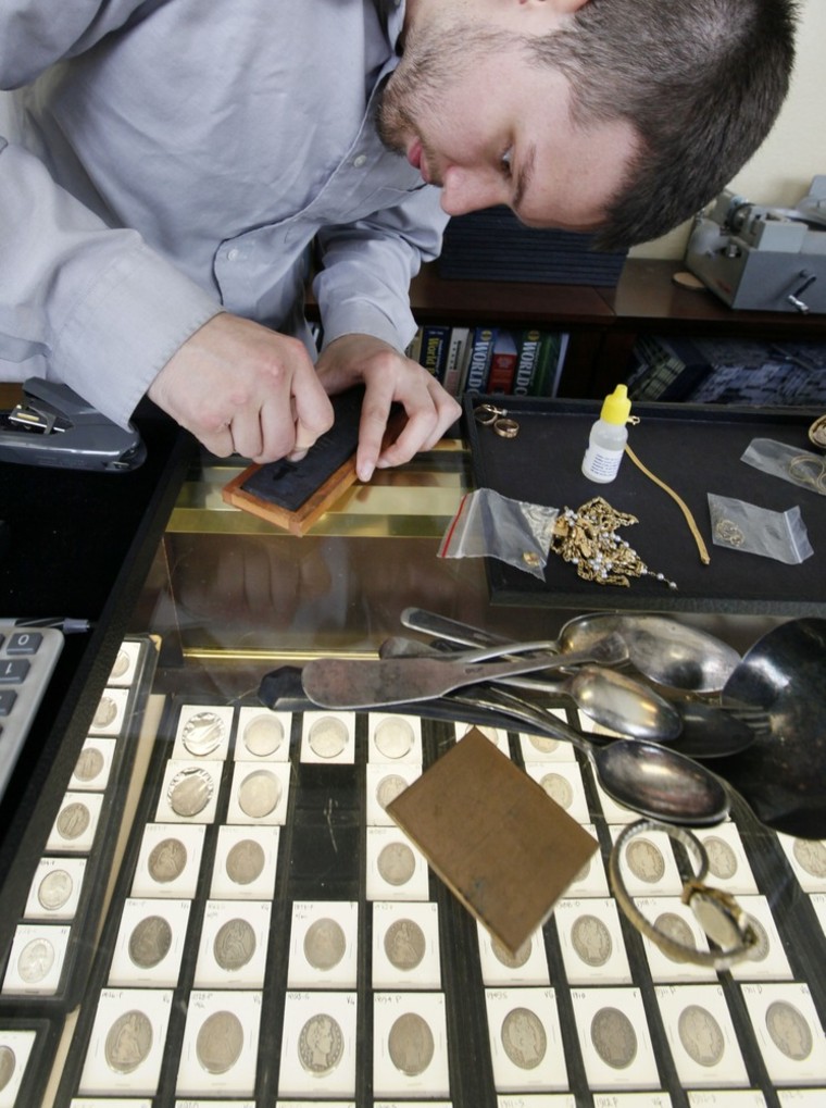 Image: Davis Hardgrove performs a \"scratch test\" on a piece of gold jewelry