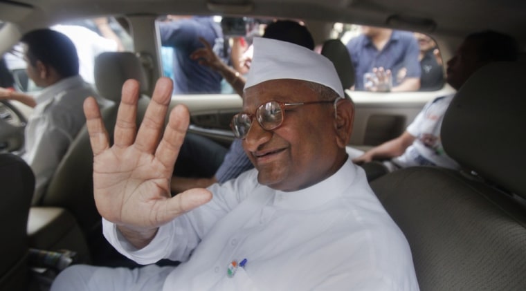 Image: Anna Hazare waves from a vehicle after being detained by police in New Delhi