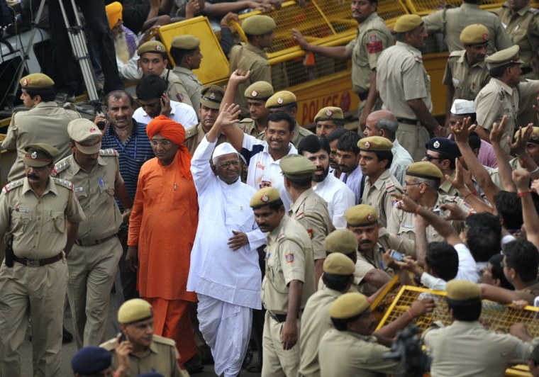 Image: Indian social activist Anna Hazare waves towards his supporters as he leaves jail