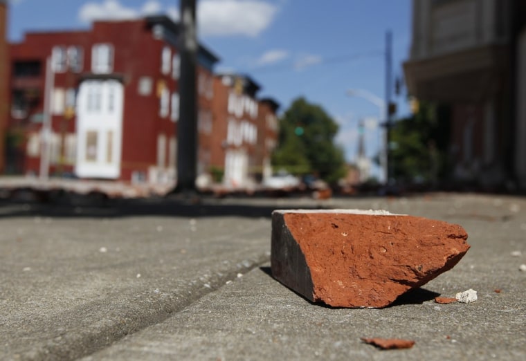 Image: A brick that fell off of a house sits on a sidewalk after an earthquake was felt in Baltimore