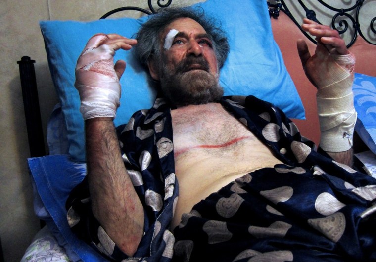 Image:Wounded Syrian cartoonist Ali Farzat rests in bed at his residence in Damascus