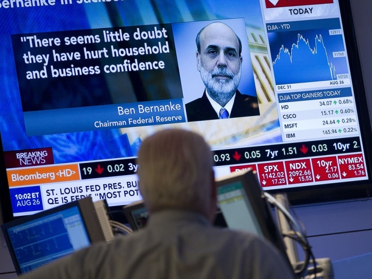 Image: A trader looks up at monitor after Federal Reserve Chairman Ben Bernanke's speech