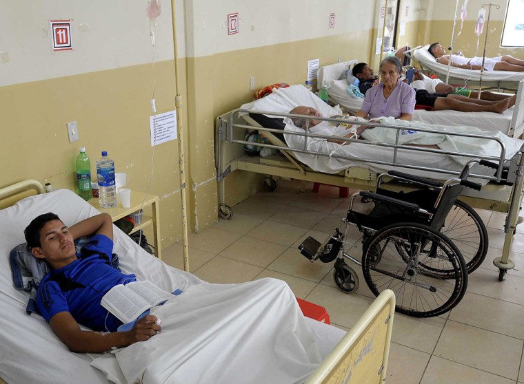Image: People intoxicated from tainted alcohol, lie in bed at the general hospital in Ricaurte, Ecuador