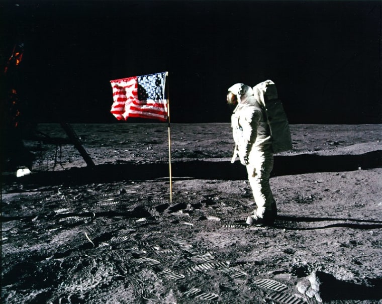 Astronaut Buzz Aldrin stands on the lunar surface after planting an American flag during the first moon landing in 1969.