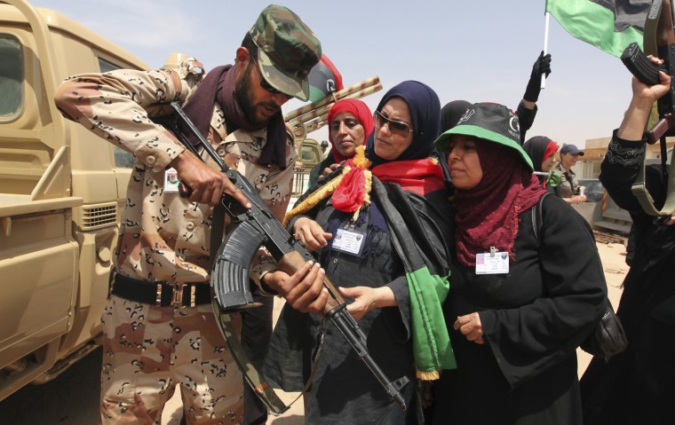 Image: A rebel army officer teaches Libyan women the use of weapons in Benghazi