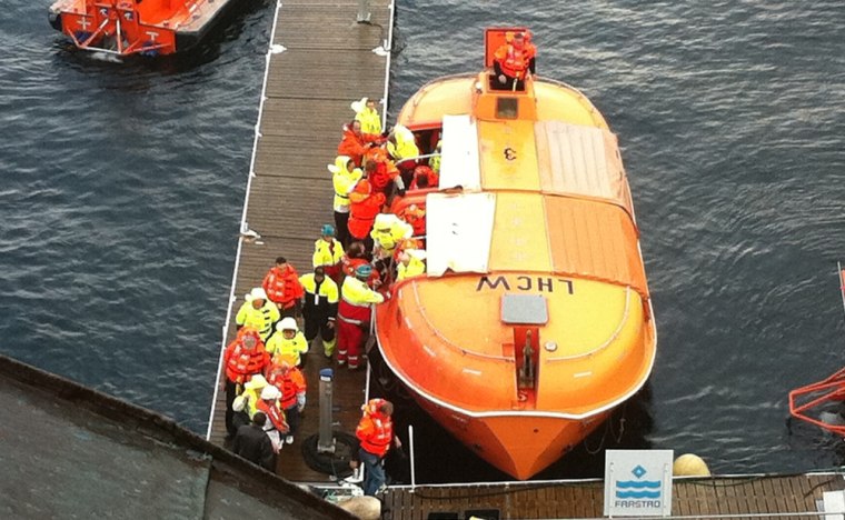 Image: Passengers are landed from a lifeboat after a fire on the Norwegian cruise ship, MS Nordlys