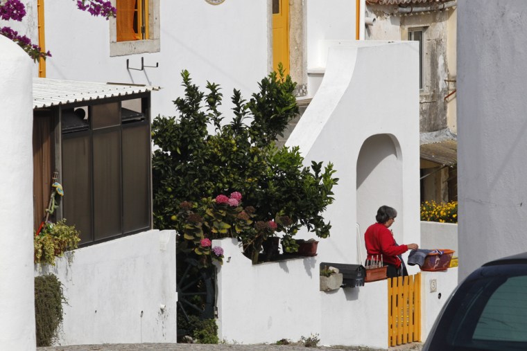 Image: A woman who said she was Maria Do Rosario Valente, the wife of fugitive George Wright  is seen outside the house where neighbors said Wright  lived in Almocagema, near Lisbon