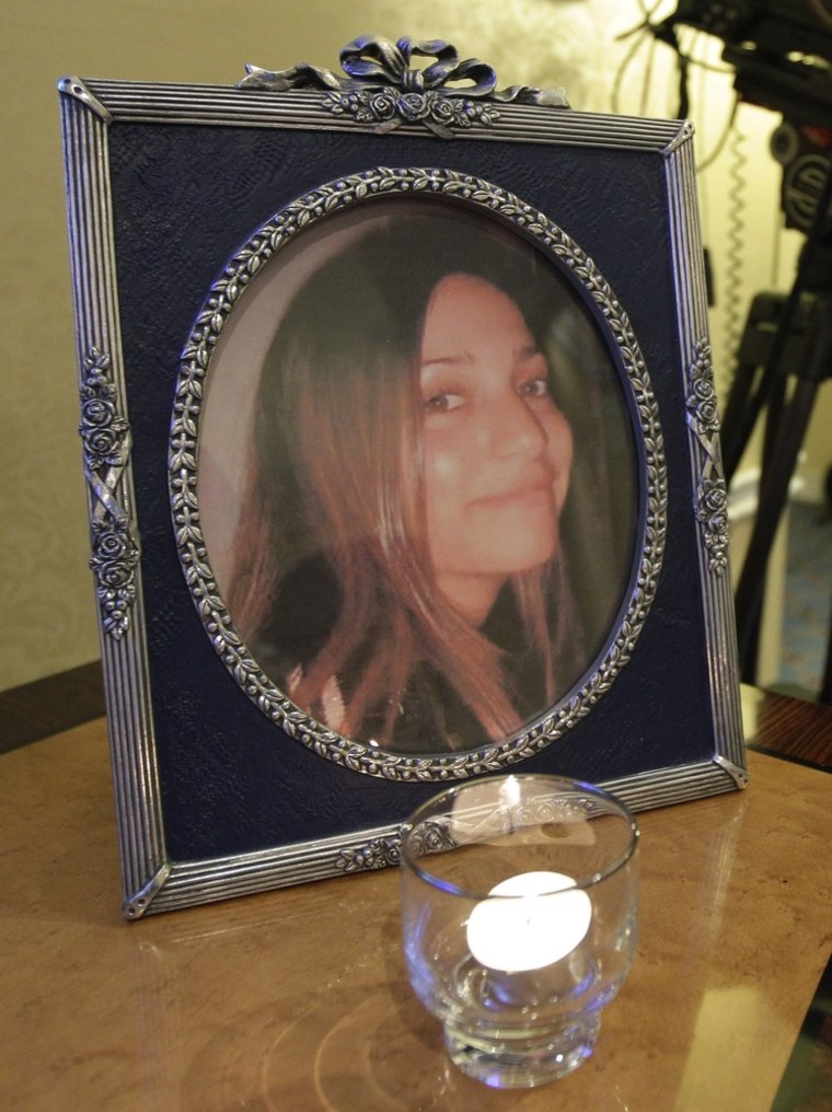 A candle burns in front of a photograph of Meredith Kercher, the British roommate of Amanda Knox, at a private overnight vigil in Seattle, in the early morning hours of Monday, Oct. 3, 2011. Supporters of Knox are awaiting a verdict from an Italian court in the appeal of her conviction in the 2007 death of Kercher that has garnered international headlines. (AP Photo/Ted S. Warren)
