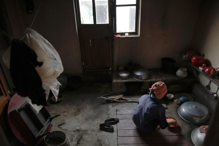 Image: A North Korean woman prepares a meal in her house at the Soksa-Ri collective farm in an area damaged by summer floods and typhoons in South Hwanghae province