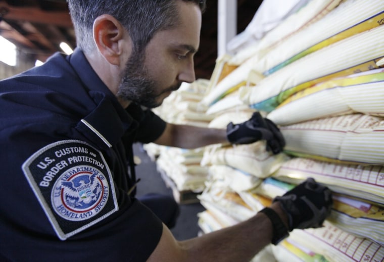 Image: Agriculture specialist Mark Murphy, with U.S. Customs and Border Protection, examines bags of rice during an inspection in Oakland, Calif.