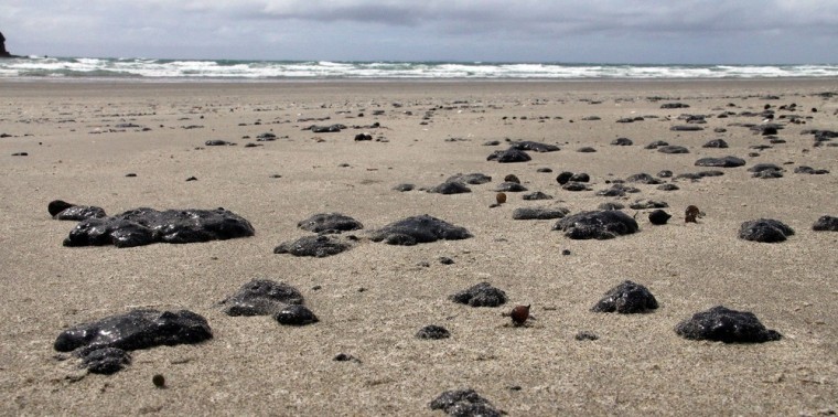 Image: Oil washed ashore from stricken container ship \"Rena\" on New Zealand's Mount Maunganui beach